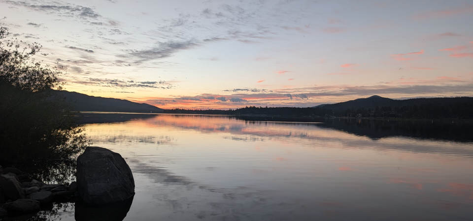 Big Bear Lake at sunset, pink cloud reflected in still water